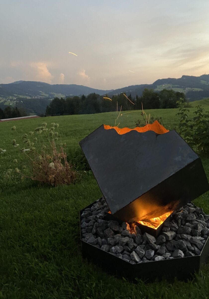 Ein modern aussehendes Outdoor-Feuerstellen Design mit einem Cube oben, für den Garten.